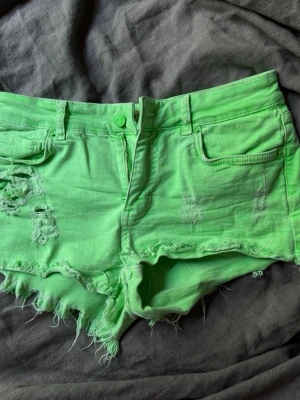Gröna slitna jeansshorts med fransar - Coola gröna jeansshorts med slitna detaljer och fransig kant. Köpte för 500, säljer då de inte passar! Perfekta i sommar, färgen är mycket pastelligare i verkligheten! Inga defekter❤️