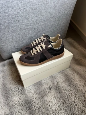 Masion margielas - Säljer ett par riktigt feta bruna/svarta gats.Använda fåtal gånger så skicket är väldigt bra(skick 9/10). Köpta på vestarie collective.storlek 40,innermått 26,5 cm 📐dustbag samt box medföljer. Har nfc scan som drar dig till masion margielas hemsida(bild 7)Hör av vid frågor 😃går ner i pris vid snabb affär 😃☺️orderbekräftelse finns😛