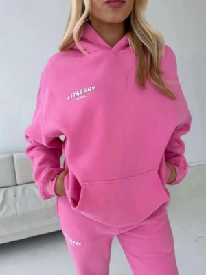 Rosa hoodie från Fitberry - Säljer en snygg rosa hoodie från Fitberry med vit logga på bröstet. Hoodien har en klassisk känguruficka framtill och mjuk, bekväm bomullsmix. Perfekt för en chill och sportig look. nypris är 1000kr