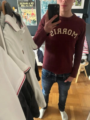 Vinröd Morris tröja - Snygg stickad Morris tröja med broderad logga på bröstet och en Storbritannien flagga på ena armen. Bra skick utan defekter! Jag är 176 cm 63 kg. 