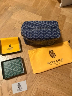 Blå handväska med monogram - Säljer en blå handväska f med deras ikoniska vita monogrammönster. Väskan har en rektangulär form . Perfekt för dig som gillar exklusiva accessoarer.