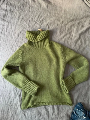 Stickad grön polotröja  - Snygg grön stickad polotröja med bred ribbad krage och muddar. Tröjan har lång ärm och är tillverkad i ett mjukt garn som känns skönt mot huden. Jättemysig på kyliga sommarkvällar❤️ passar M/S
