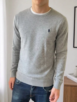 Grå Ralph Lauren Tröja - Säljer en sjukt fet raffe tröja i färgen grå. Hoodien är i bra skick förutom att lappen är borta fast de är inget som syns eller påverkar själva tröjan, men skulle säga att tröjan sitter som M. Hör gärna av er vid frågor eller funderingar!! 