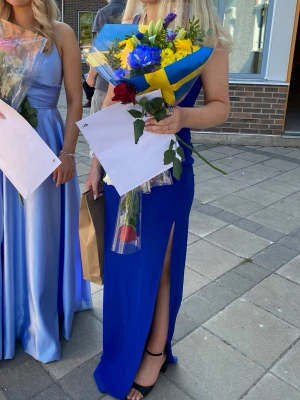 Kornblå långklänning med slits - Säljer min SUPER FINA balklänning, en kornblå långklänning med hög slits på ena sidan. Klänningen har figurnära passform som framhäver siluetten. Perfekt för bal, student eller festligare tillfällen. 💙Endast använd en gång och i helt nytt skick! Säljer för 500kr (köpt för 899kr) MEN pris kan diskuteras🩵🌟