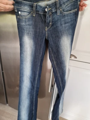 Blå jeans från Weekday - Snygga blå jeans med ljusa slitningar framtill. Utsvängda modell. Köpte från Weekday.