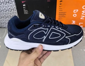 Mörkblå sneakers med vit sula - Snygga mörkblå sneakers från  med stora -bokstäver på sidan. Ovandelen är i mesh och mocka, med vita detaljer och en tjock vit sula. Skorna har sportig design och klassisk snörning. Perfekta för dig som gillar streetwear och exklusiva märken.