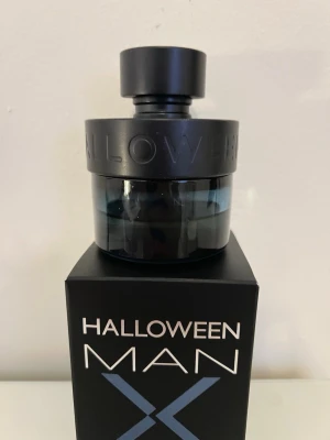 Halloween Man X parfym 50 ml - Halloween Man X är en parfym för män med en stilren, rund flaska i mörkblått glas och svart lock. Flaskan rymmer 50 ml och har en modern design med tydlig logotyp. Kommer i originalförpackning med svart och blå detaljer. Runt 20ml kvar