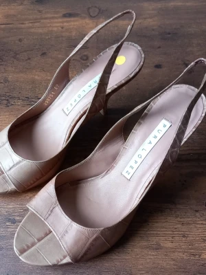 Pura López beige pumps med krokopräglat mönster storlek 39 - Snygga pumps från Pura López i beige färg med krokopräglat mönster. Modellen har öppen tå, smal klack och slingback-rem. Tillverkade i läder för en lyxig känsla och stilren look.