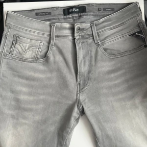 Replay Anbass Hyperflex grå jeans W31 L32 - Snygga grå jeans från Replay, modell Anbass Hyperflex. Jeansen har klassisk femficksdesign, normal passform och stretchigt material som gör dem riktigt bekväma. Perfekta för dig som gillar stilrena och moderna jeans med en cool tvätt. Skriv om du är intresserad eller vill ha mer bilder