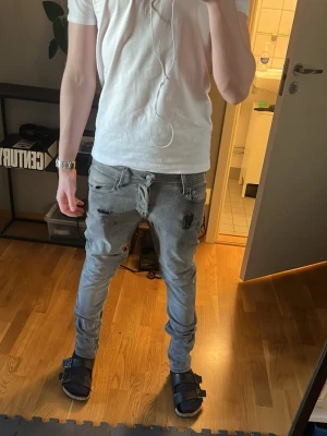 Grå slim fit jeans med slitningar - Säljer ett par grå slim fit jeans från Jack and Jones  med snygga slitningar och detaljer på benen.