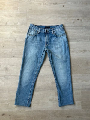 Blåa Nudie Thin Finn Jeans Storlek W31 L32 - Fina Nudie Jeans i blå färg. Jeansen är i mycket bra skick och sparsamt använda. |  Äkta som allt annat jag säljer! ✅ |  Storlek: W31 L32 - Lite korta i längden (SE MÅTT PÅ BILDER) | Skick: Mycket Bra Skick - 2 väldigt små fläckar (SE SISTA 2 BILDER) | Färg: Blå | Märke: Nudie | Modell: Jeans |   Hör gärna av dig vid frågor så svarar jag så fort jag kan! 😁 |  