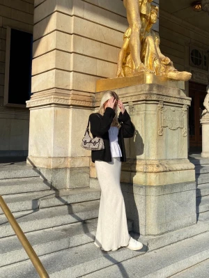 Superfin långkjol  - Superfin långkjol i en mjuk beige/cremefärg från Urban outfitters. Den har en figurnära passform som faller snyggt längs kroppen och passar perfekt både till vardag och lite mer uppklädda tillfällen.