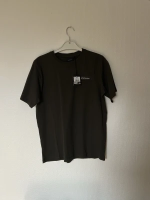 Svart t-shirt från Peak Performance - En stilren grön  t-shirt från Peak Performance med klassisk rund hals och diskret logga på bröstet. Tillverkad i mjuk bomull för skön känsla och perfekt passform. Enkel att matcha med allt och ett måste i garderoben.