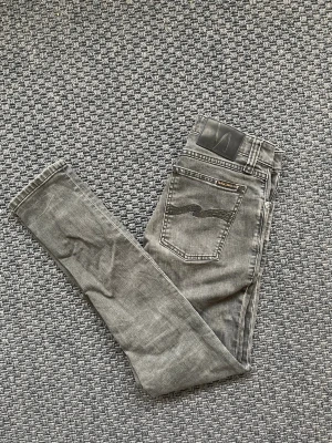Grå slim fit jeans från Nudie Jeans - Säljer nu dessa sjukt snygga slim jeans från Nudie jeans i perfekt skick 😊 Passar till allt och passformen är helt perfekt🙌 Skriv vid funderingar 📲🤝