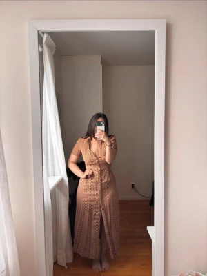 Vintage style långklänning  - Säljer en långklänning med korta ärmar och knappar framtill. Perfekt för sommarens alla tillfällen!