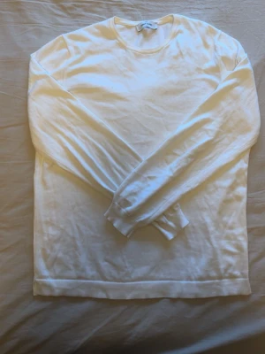 Vit stickad tröja Gran Sasso - Klassisk vit stickad tröja från Gran Sasso med rund halsringning och långa ärmar. Tillverkad i mjukt material som ger en clean och stilren look. Perfekt att matcha med jeans eller chinos för en enkel men snygg outfit.