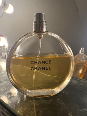 Chanel Chance parfym  - Äkta Chanel säljer för mindre pris pågrund av skador på bilderna  Chance parfym i rund glasflaska med silverfärgad spraykork. Flaskan har en stilren design med svart text och innehåller en guldfärgad vätska. Perfekt för dig som gillar exklusiva dofter och klassisk stil. 