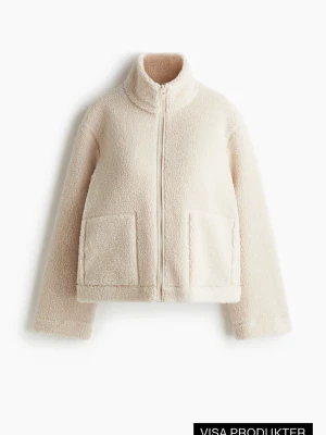 Beige teddyjacka med dragkedja - Mysig beige teddyjacka med hög krage och dragkedja framtill. Jackan har två stora fickor framtill och är tillverkad i fluffigt teddy-material som ger en avslappnad och trendig look. Perfekt för att hålla värmen under kyliga dagar.