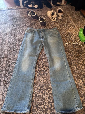 Bootcut jeans  - Säljer ett par ljusblå jeans med rak passform och klassisk femficksdesign. Jeansen har normal midja och är tillverkade i denim. Perfekta för en avslappnad och stilren look.