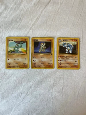Pokémonkort Machop & Machoke 3-pack - Tre Pokémonkort med Machop och Machoke. Korten har klassisk design med gul ram och motiv i färg. Baksidan är blå med Pokéball och Pokémon-logga. Perfekt för samlare eller Pokémonfans som vill utöka sin kortsamling. Dom är i mycket bra skick. Jag försöker sälja några av mina dubbletter som jag har fått. Hör av er ifall ni vill lägga ett bud eller köpa!👍🏽