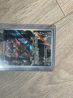 Pokémonkort Doublade holografisk - Säljer ett Pokémonkort med Doublade-motiv. Kortet är holografiskt och har en futuristisk design med metalliska och lila detaljer. Kortet ligger i ett genomskinligt plastfodral. Perfekt för samlare eller Pokémonfans.