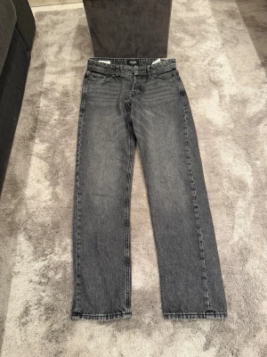 Grå raka jeans från Jack & Jones - Svarta raka jeans från Jack & Jones (Chris). Passformen är loosefit och storleken är 31/34. Mycket gott skick!
