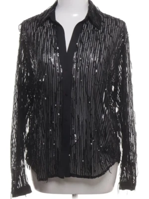 Svart skjorta med paljetter storlek m zara - Snygg svart skjorta med glittriga paljetter och knappar framtill. Skjortan har lång ärm och ett transparent tyg som ger en cool och trendig look. Perfekt för dig som vill sticka ut lite extra.