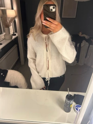 Vit stickad tröja med knytning - Säljer denna söta stickade tröjan från Ginatricot för att den aldrig kommer till användning. Väldigt bra skick!