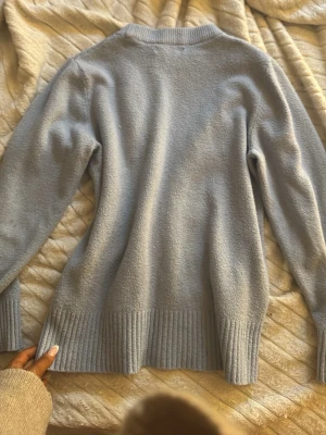 Ljusblå stickad tröja - Super fin blå stickad tröja,litet hål som går att sy ihop. Super snygg när man är brun i sommar!😍