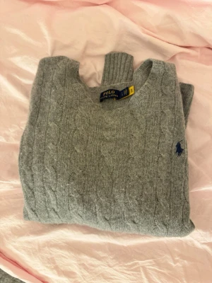 Grå Polo Ralph Lauren Stickad Tröja - Grå stickad tröja från Polo Ralph Lauren. Så skönt material, jättego💓💓Knappt använt den alls. Storlek: ❌står strl L men sitter som S!!❌