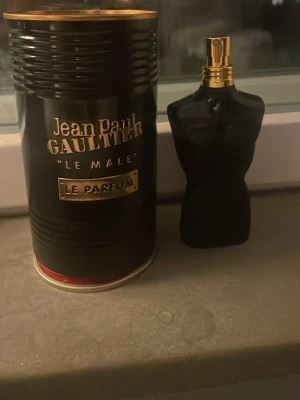 Jean Paul Gaultier Le Male Le Parfum - Jean Paul Gaultier Le Male Le Parfum är en herrparfym i en svart, kroppformad flaska med guldfärgad spraytopp. Förpackningen är en svart metallcylinder med guldtext och detaljer. Doften är intensiv och maskulin, perfekt för dig som vill sticka ut. Lite mer än halva kvar