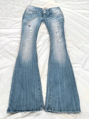 Superlågmidjade ljusblå bootcut jeans - Såååå sjukt snygga vintage superlågmidjade ljusblå bootcut  jeans med slitningar! 😩😩🙏🏼💓 Innebenslängd: 84 cm Midjemått: 38 cm 