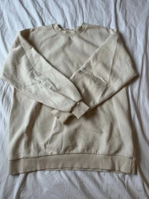 Beige sweatshirt i bomull - En stilren beige oversized sweatshirt med rund hals och ribbade muddar vid ärmslut och nederkant. Tillverkad i mjuk bomull som känns skön mot huden.