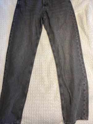 Grå relaxed fit jeans RELAXED/CHRIS - Säljer ett par grå jeans i relaxed fit-modell från RELAXED/CHRIS. Jeansen har rak passform och klassisk femficksdesign. Perfekta för dig som gillar en avslappnad stil och vill ha ett par bekväma jeans i garderoben.