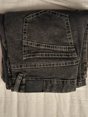 Gråa raka jeans från Gina Tricot - Säljer ett par gråa jeans från Gina Tricot med rak passform och klassisk femficksdesign. Jeansen har tydliga kontrastsömmar och är tillverkade i ett slitstarkt denimtyg. Perfekta för en avslappnad och trendig look. Finns på fler sidor 
