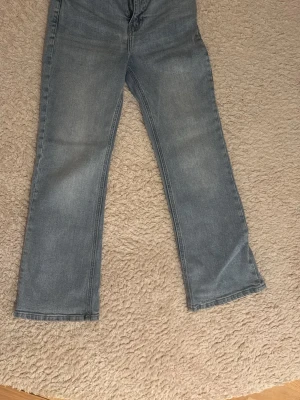 Ljusblå raka jeans - Säljer ett par ljusblå  högmidjade jeans som är cirka 1 år gamla. Använda men i fint skick utan hål eller men är lite slitna på baksidan med till foten. Bekväm passform och perfekt både till vardag och fest. 