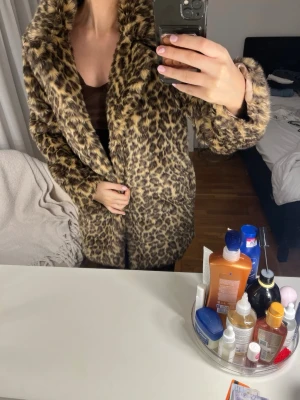 Leopardmönstrad pälsjacka från NAKD - Säljer en fluffig leopardmönstrad pälsjacka från NA-KD med bred krage och mjukt foder. Jackan har en klassisk rak passform och stängs framtill. Perfekt statement-plagg för dig som vill sticka ut i vinter!