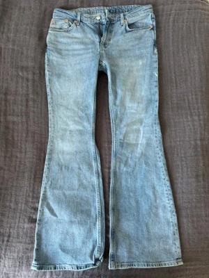 Ljusblå bootcut jeans från Weekday - Super snygga bootcut jeans från Weekday med låg midja. Perfekt fin ljusblå färg inför våren och sommaren! Efterfrågade och trendiga jeans och passformen är jätte skön. De är i storlek 29x32 och passar mig som vanligt vis har 38. Fråga gärna om mått!