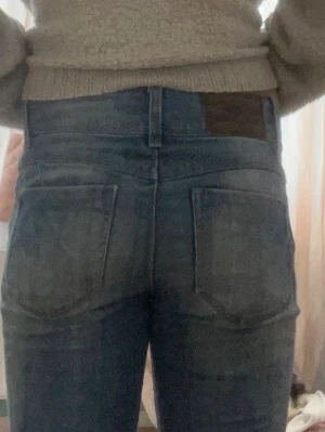 Mörkblå bootcut  jeans med dubbel knappar - Säljer ett par mörkblå jeans med bootcut och dubbel knappar . Jeansen har klassiska bakfickor och bälteshällor. Materialet är denim i bomull och de har en enkel, tidlös look som passar till det mesta.