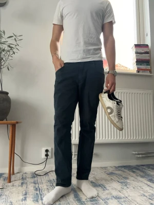 Svarta raka jeans från Wrangler - Säljer ett par mörkblåa jeans från wrangler modell ”River” med rak passform och klassisk femficksdesign. Jeansen har normal midja och är tillverkade i ett mjukt denimtyg. Perfekta för en clean och stilren look. Storleken på papper är W30 och L32 men jag har klippt ner jeansen så nu är dom närmare L30. Midjan passar dom som har upp till storlek W31 kanske W32. Jeansen har inga tecken på användning och inte heller några permanenta fläckar. Hör av er vid frågor eller om bilder😊