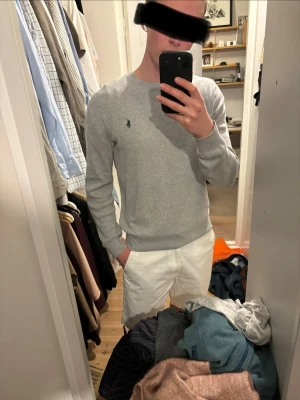 Grå stickad tröja från Polo Ralph Lauren - Säljer en stilren grå stickad tröja från Polo Ralph Lauren med den klassiska logon broderad på bröstet. Tröjan har rund hals, långa ärmar. Perfekt för en avslappnad och trendig look. 