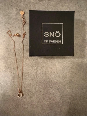 Halsband i roséguld från SNÖ of Sweden - Snyggt halsband i roséguld från SNÖ of Sweden med en cirkelformad berlock dekorerad med gnistrande pärlor. Helt nytt med ask.