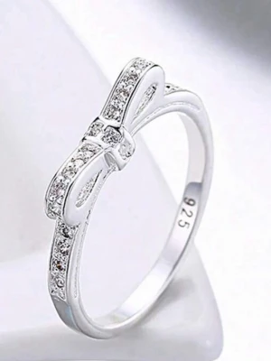 Söt silverring med rosett och stenar - En stilren och söt ring  (925) med en glittrande rosett framtill. Ringen är dekorerad med små klara stenar längs bågen och rosetten, vilket ger en elegant och lekfull look. Perfekt för dig som gillar detaljer och vill ha något unikt.