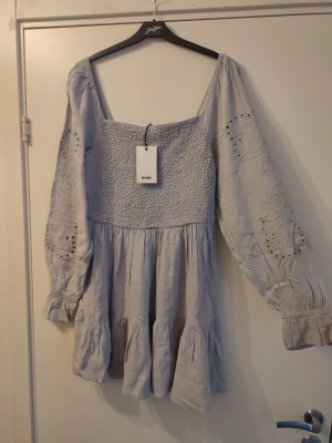 Ljusgrå klänning storlek M - Vacker ljusgrå klänning med fina detaljer. Helt ny, aldrig använd, med lappar kvar! Ord.pris 699kr. Storlek M.