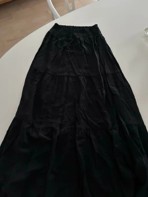 Svart långkjol med resårmidja - Säljer en svart långkjol från lager 157. Kjolen är i storlek S. Den passar till allt och har ett väldigt skönt material! Säljer då den tyvärr är för kort för mig. 