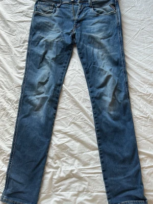 Replay jeans Vaist 31 Lenght 32 - Säljer ett par klassiska blå jeans med raka ben och kontrastsömmar. Jeansen har fem fickor och subtila slitningar framtill för en avslappnad look. Perfekta till sneakers eller boots och passar till många olika stilar.
