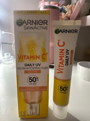 Garnier Vitamin C Daily UV Glow Foundation - Foundation från Garnier med Vitamin C och SPF 50+. Ger glow och skyddar huden mot UV-strålar. Kommer i en tub med vit och gul design. Perfekt för dig som vill ha lyster och jämnare hudton.