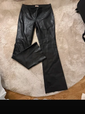 Svarta skinnbyxor från Nelly - Snygga svarta skinnbyxor från Nelly i nyskick. I strl 36. Jag är 166 