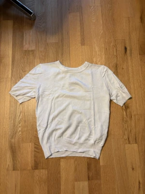 Puffärm topp - En enkel och stilren vit topp från Zara med korta ärmar och rund hals. Tillverkad i mjukt material som känns skönt mot huden. Perfekt att matcha med jeans eller kjol för en clean look.