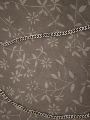 Tjock silverfärgad kedja  - Säljer ett stilrent halsband med platt, bred kedja i silverfärg. Halsbandet har en klassisk design med tätt sammanlänkade länkar som ger ett snyggt och modernt intryck. Perfekt för dig som gillar enkla men ändå iögonfallande accessoarer.